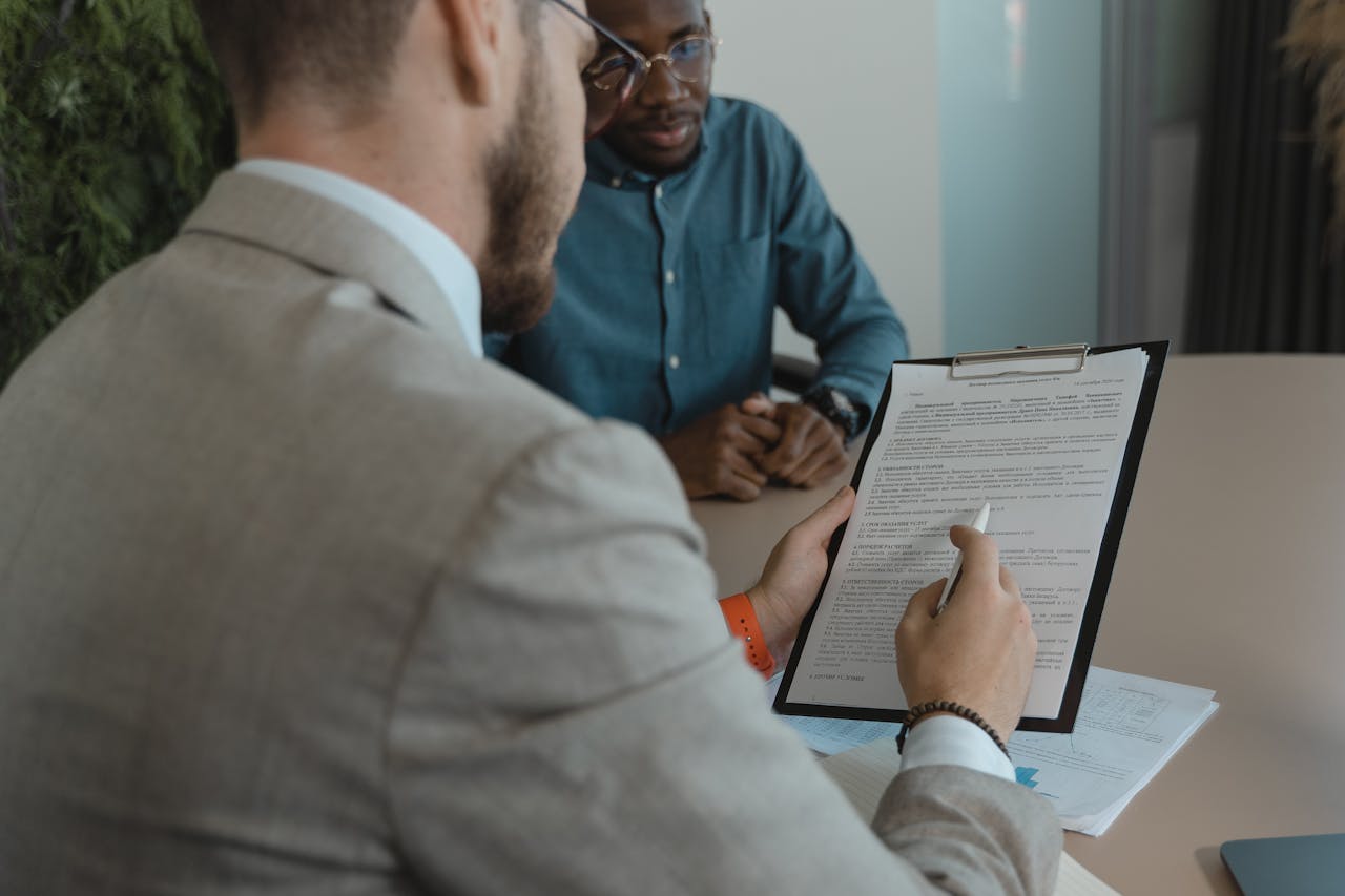 services-04 A recruiter reviews a candidate's documents during a job interview in a modern office setting.